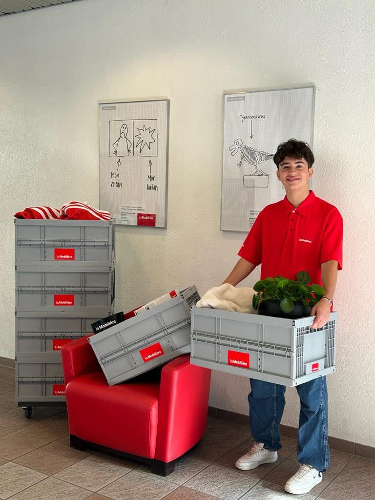 Un jeune homme tient les cartons de déménagement de la Mobilière dans les mains.