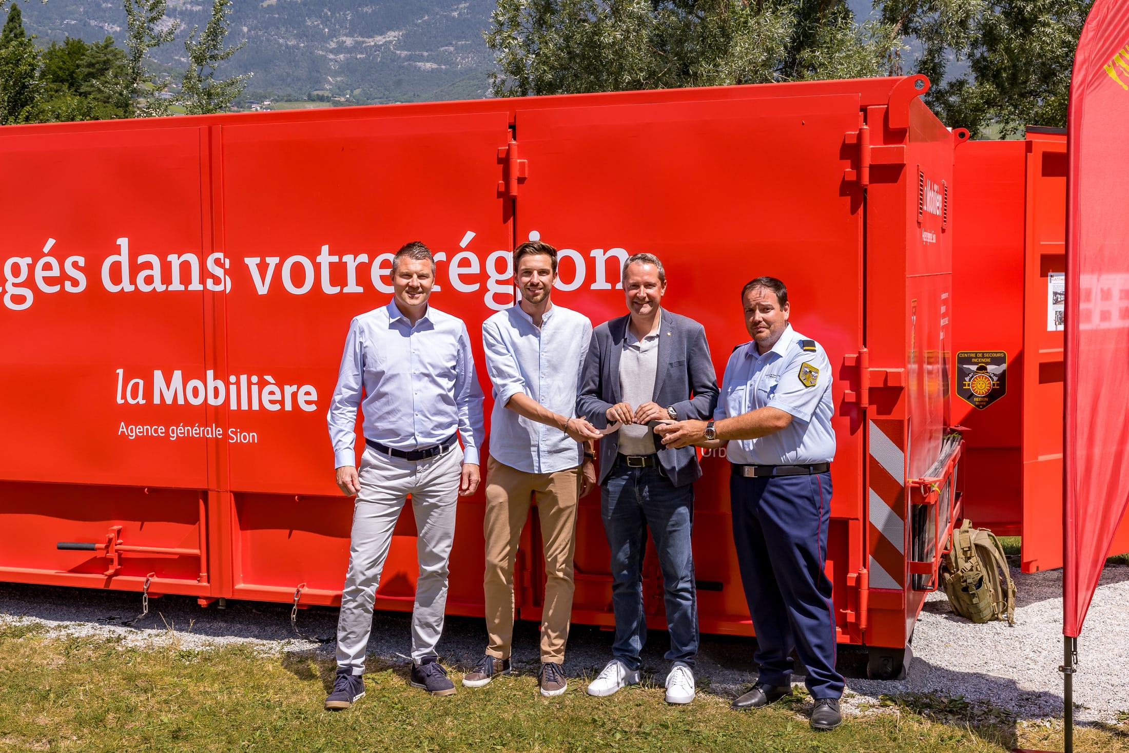 Quatre personnes se tiennent devant un container Mobilière