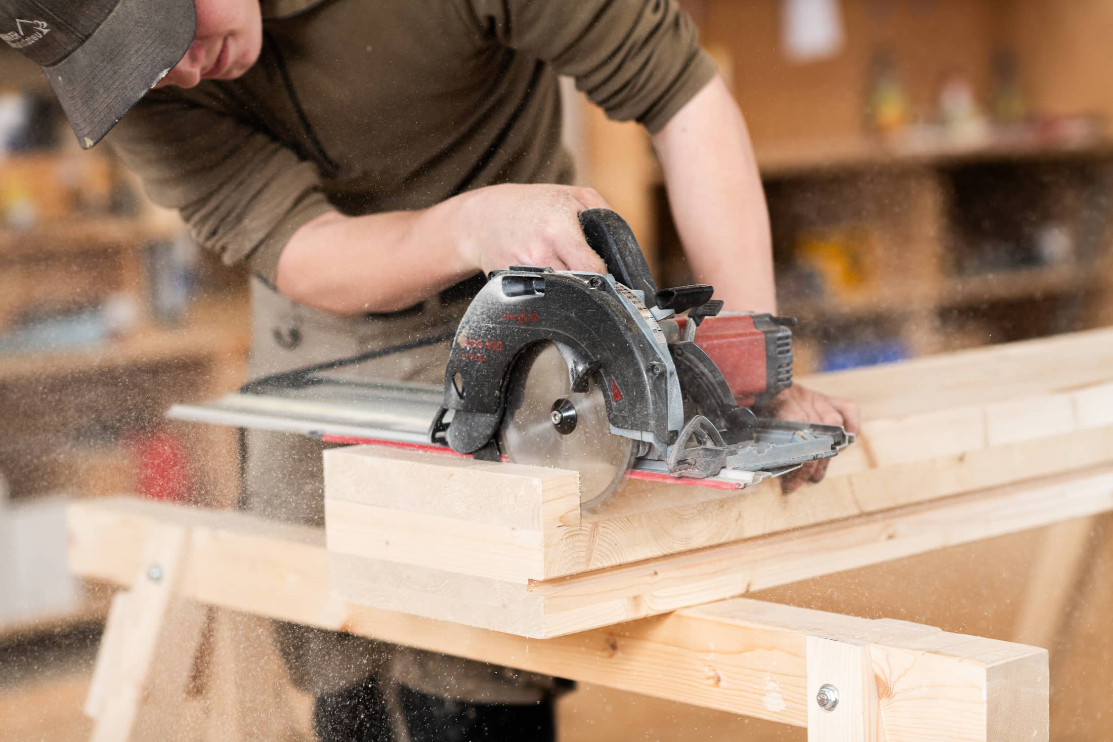 Un apprenti de l’entreprise Herger Klimaholzbau au travail avec une scie circulaire. 