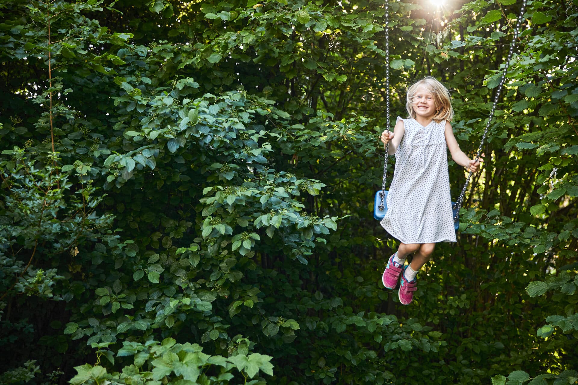 Mädchen im Garten auf einer Schaukel